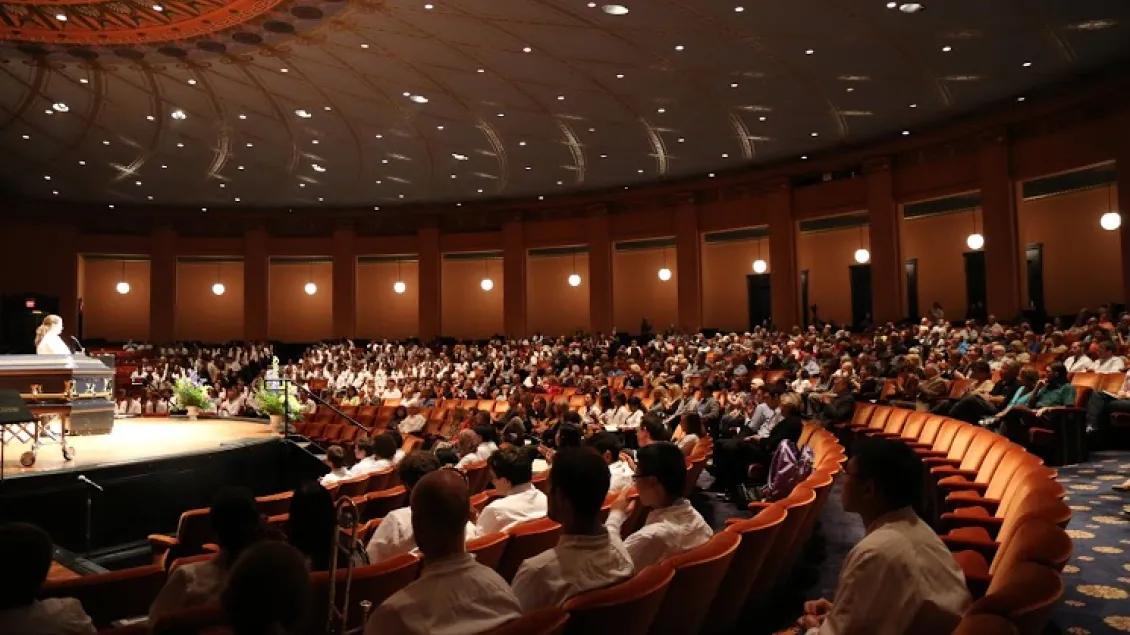An auditorium with many people watching a presentation