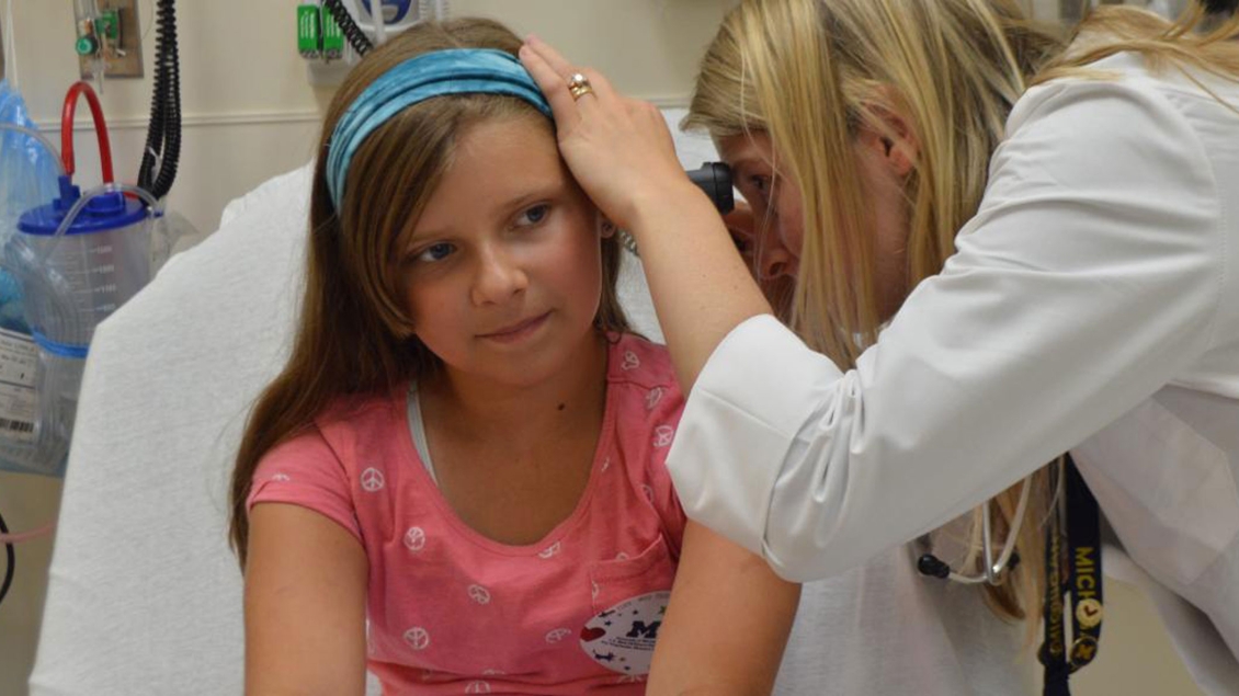 Doctor examines inside patient ear