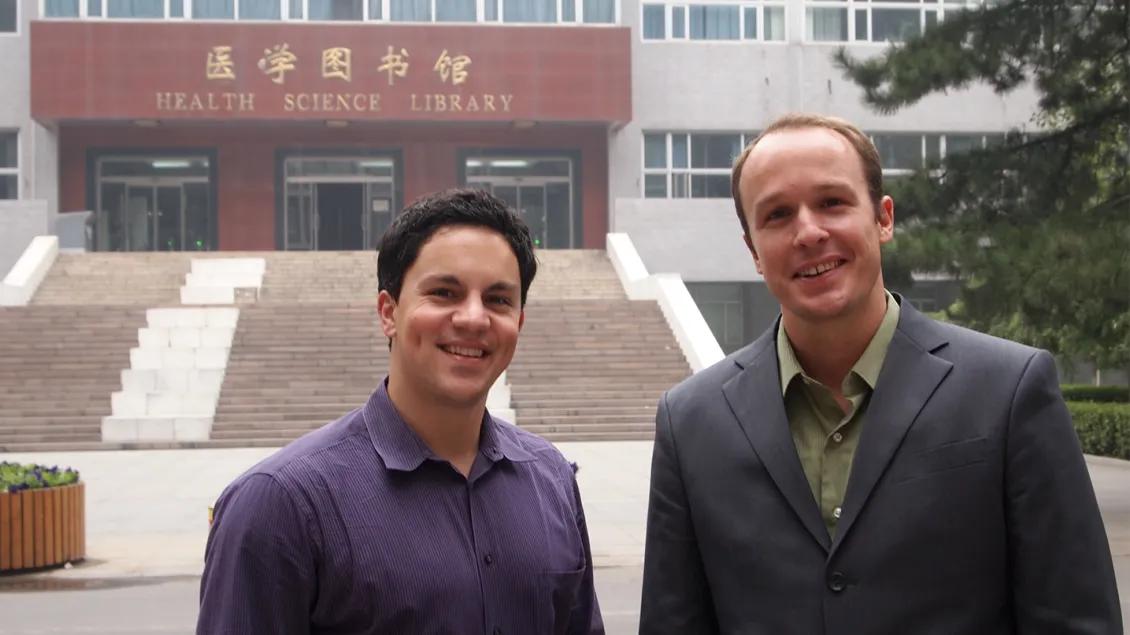 Two people in front of a building in China