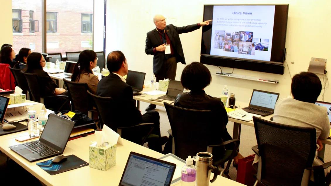 A classroom of people watching a presenter