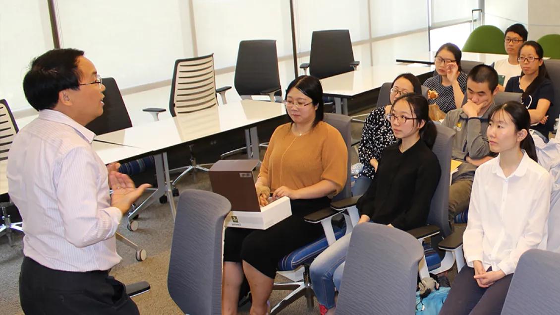 A classroom of people listening to a presenter