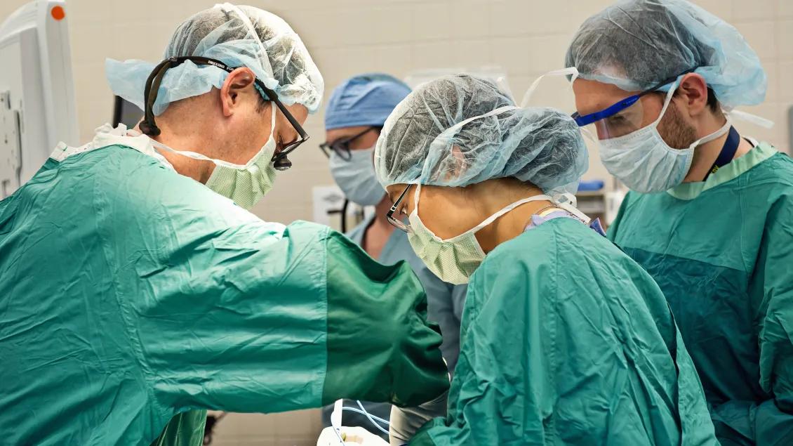 A team of surgeons operating in an operating room
