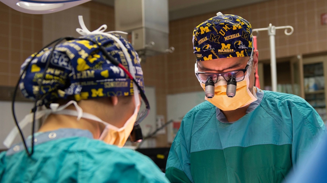 Two surgeons focused on a procedure in an operating room