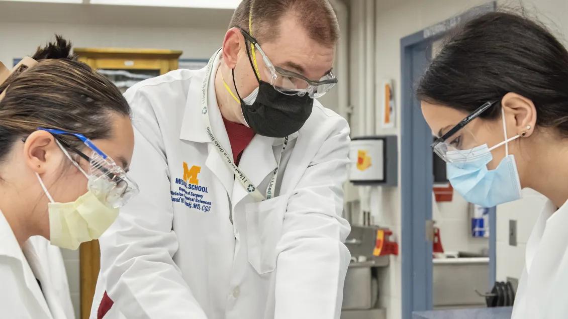 Faculty member and students working in the anatomy lab