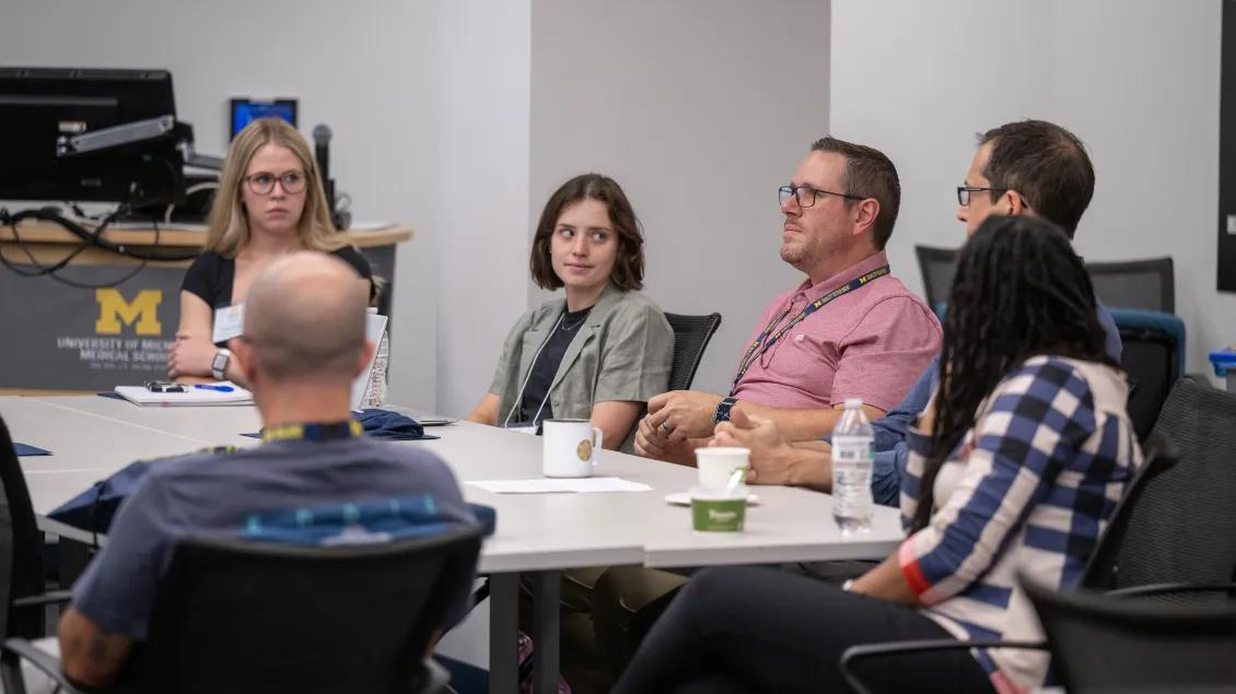 People sitting at tables and talking in a classroom