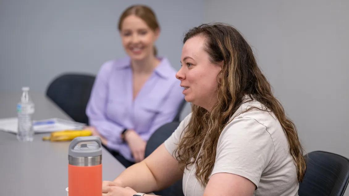 People sitting at a table and talking in a classroom