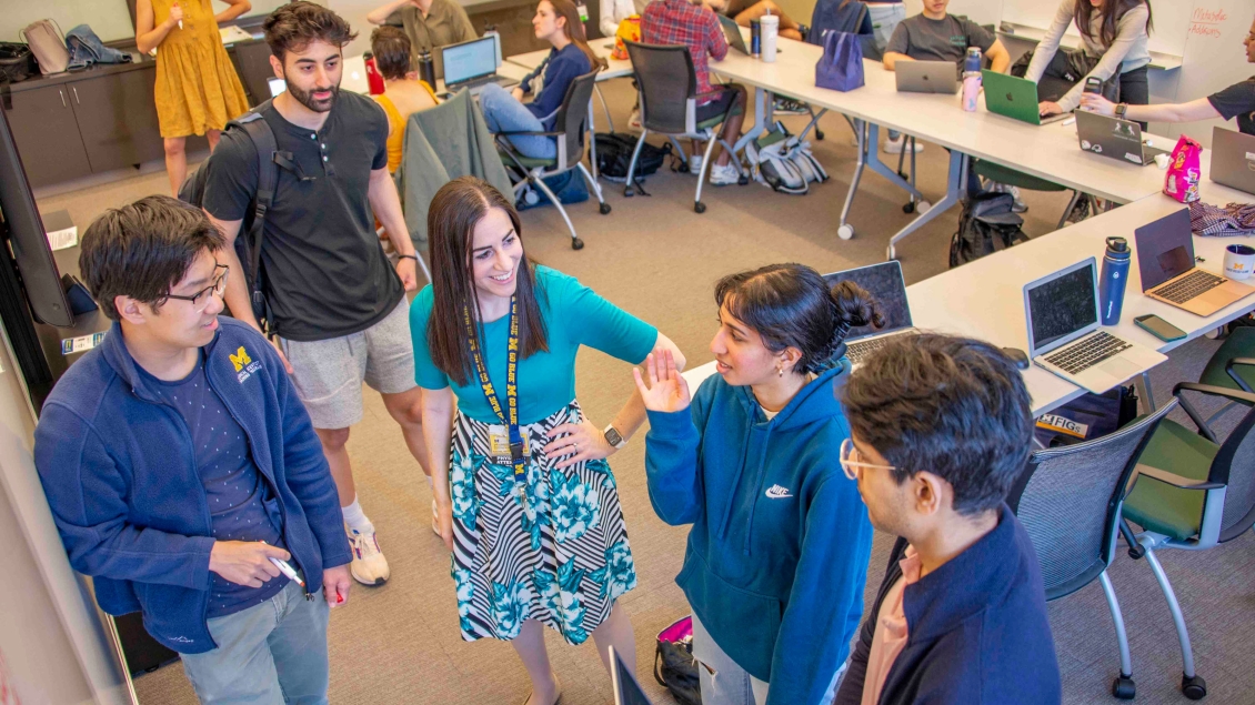 Medical students speaking with faculty in a classroom