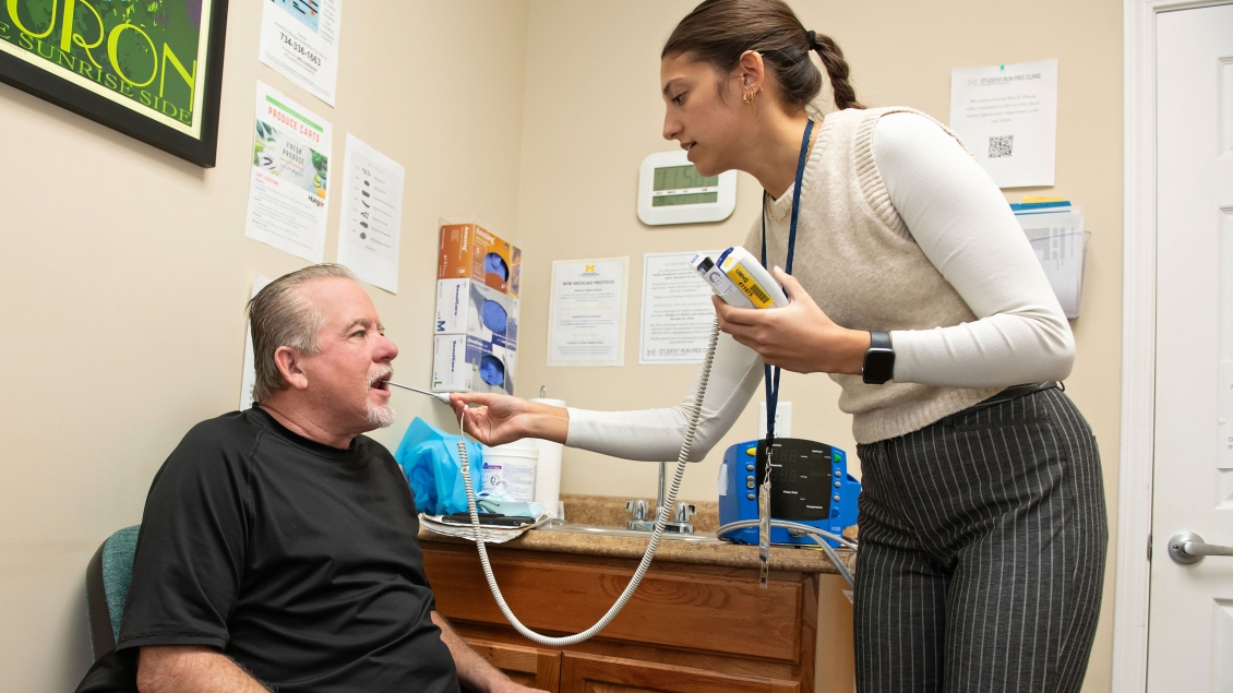 A medical student takes a patient's temperature