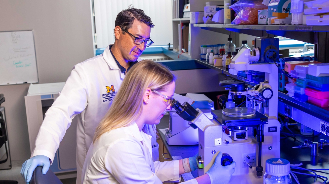 Faculty member and student working with equipment in a lab