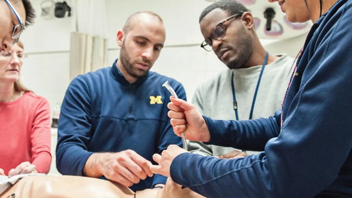 A group of people working with a simulation dummy