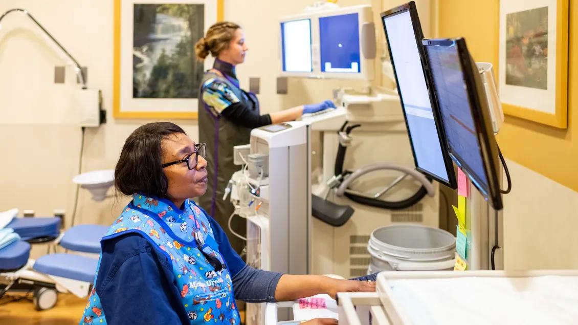 Female provider looks at computer screen at hospital