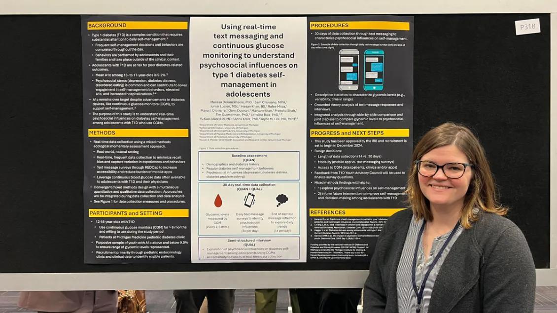  A woman at the 2024 NAPCRG stands before a presentation board.