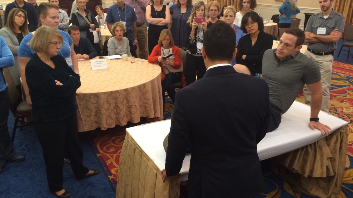 A person speaking infront of a large group of people