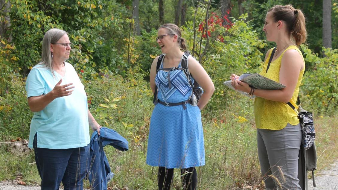 Three people talking outside