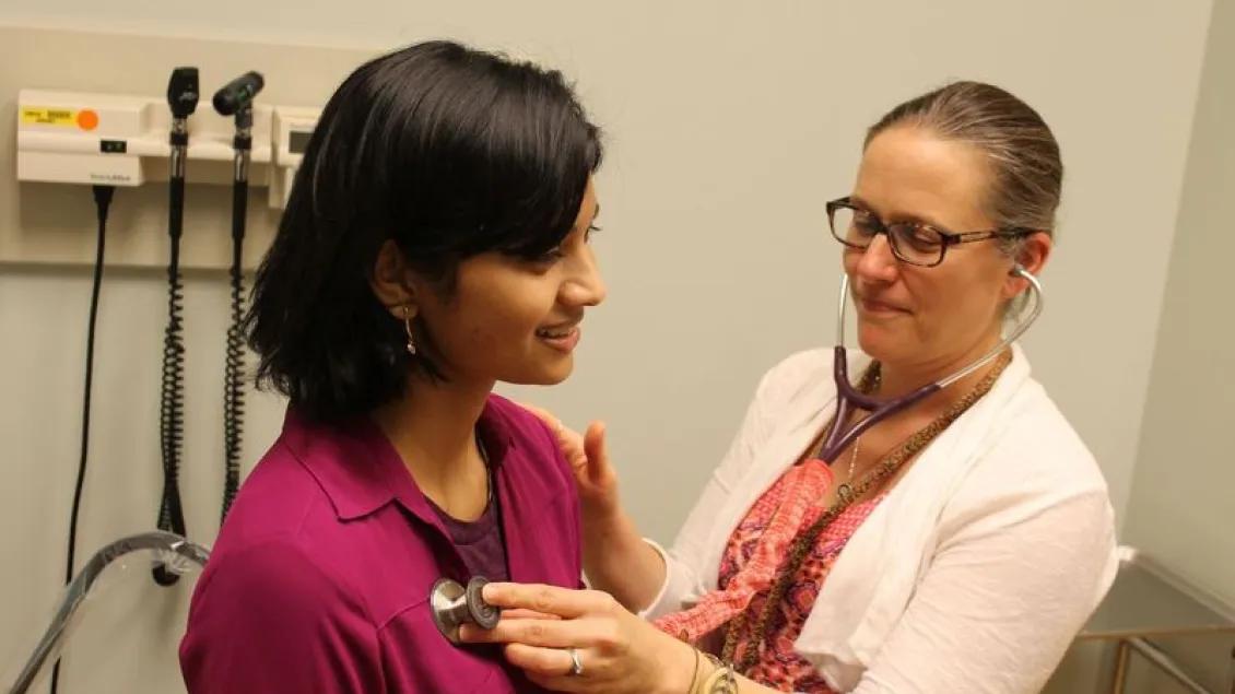 A patient with a doctor in an exam room