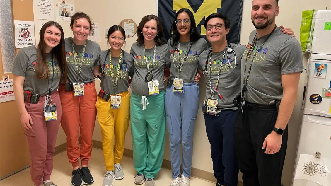 Pediatrics team wearing colorful scrubs posing for camera