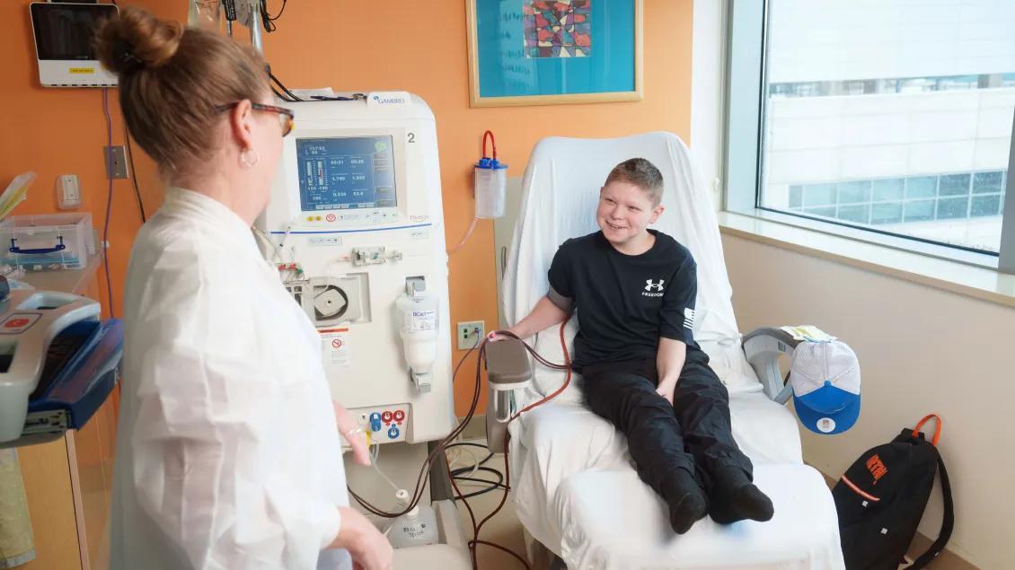 Physician at MOTT hospital talking to infusion patient.