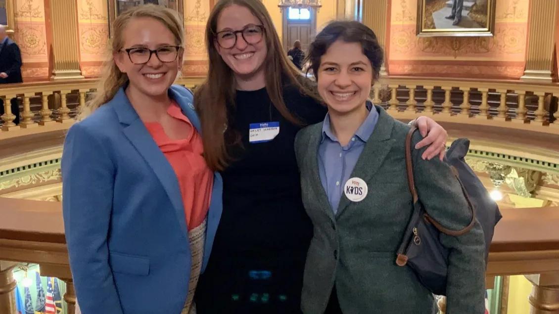 Three staff members take a photo at an advocacy building