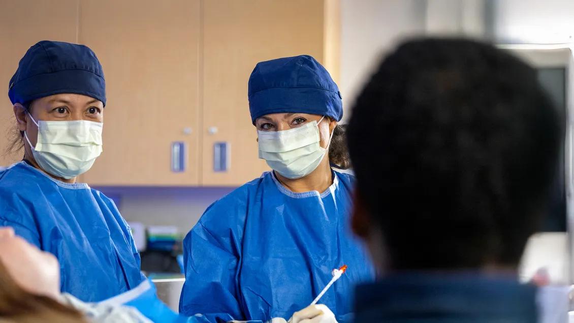 Masked Radiology providers speak with a patient
