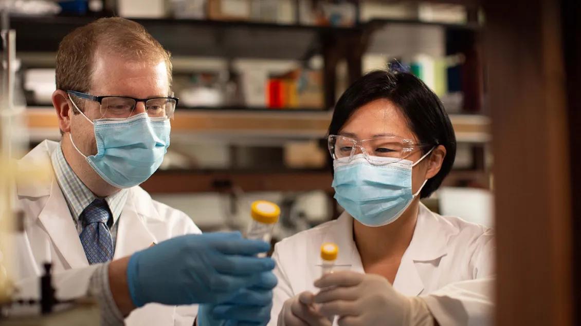 Drs. Daniel Wahl and Yoshie Umemura in the lab comparing notes