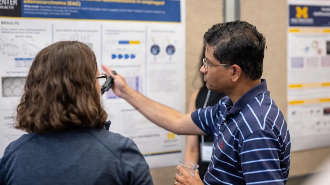 Two people talking at a presentation poster