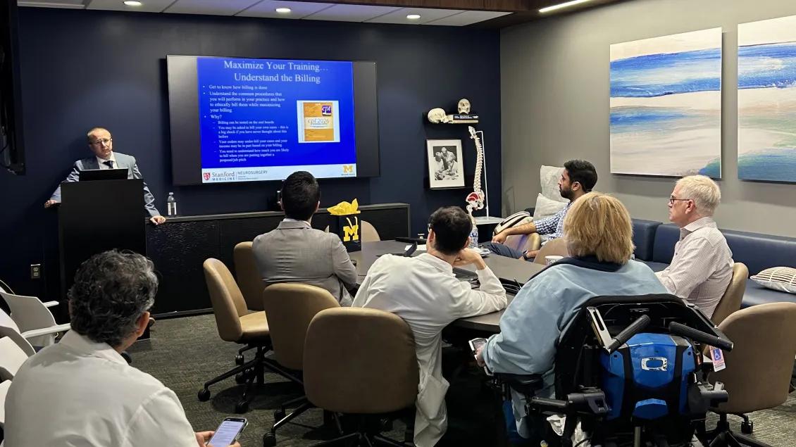 A group of people attending a lecture with a slideshow on a projector