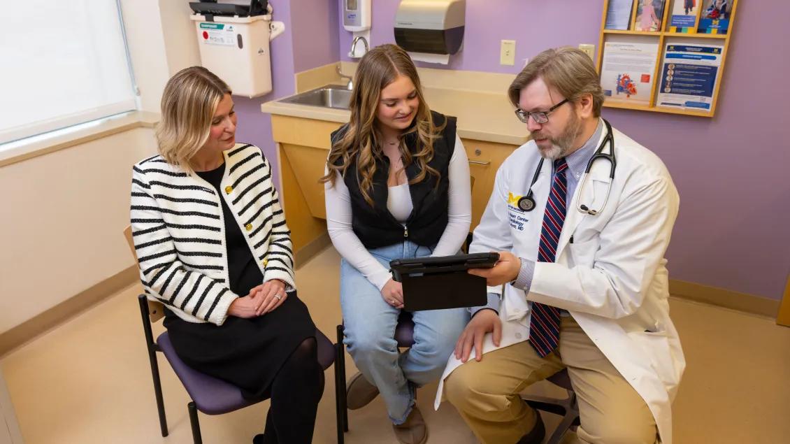A group of people in a patient room reviewing data together