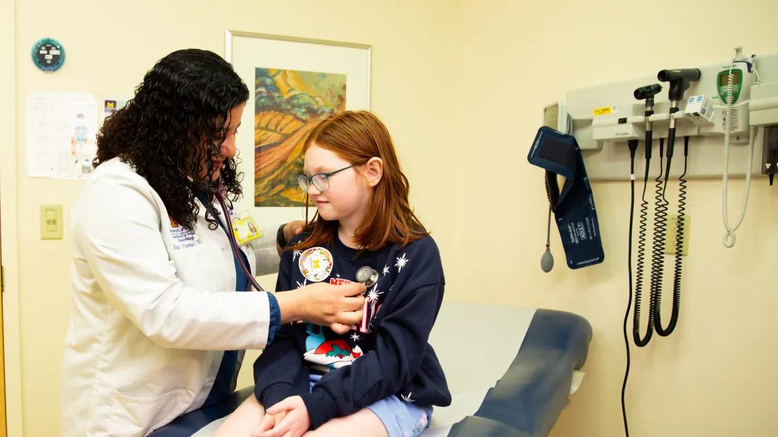 A doctor working with a pediatric patient in an exam room