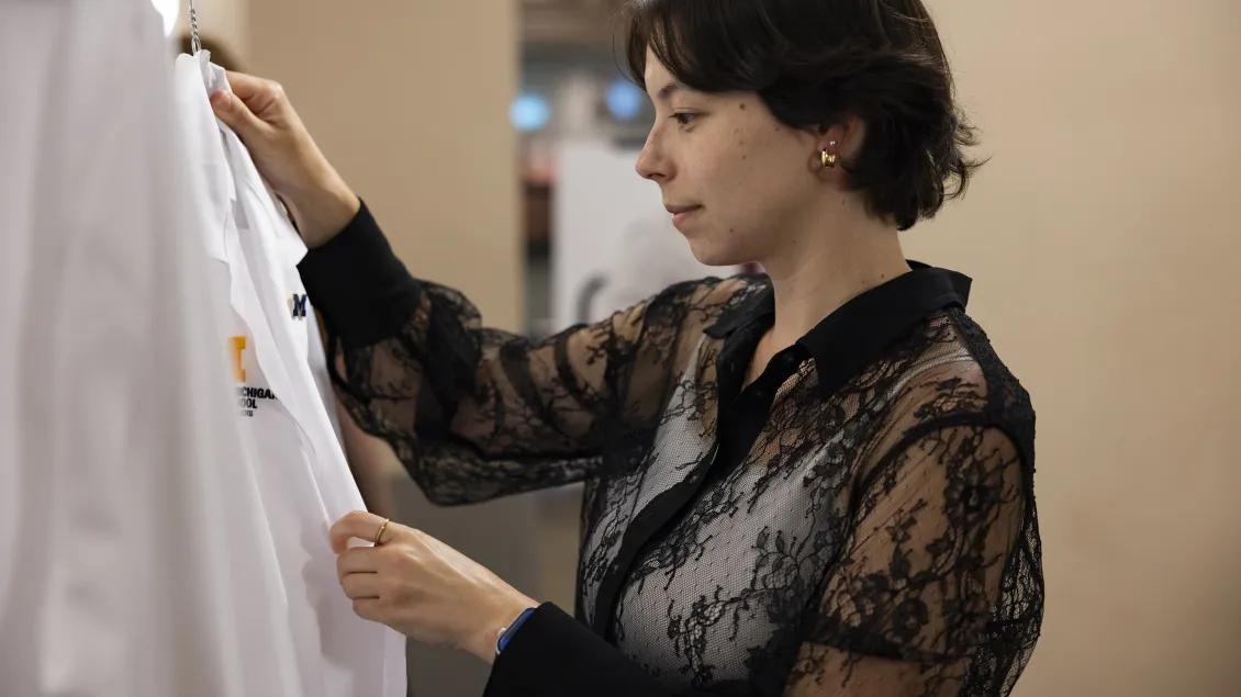 a woman touches a medical white coat