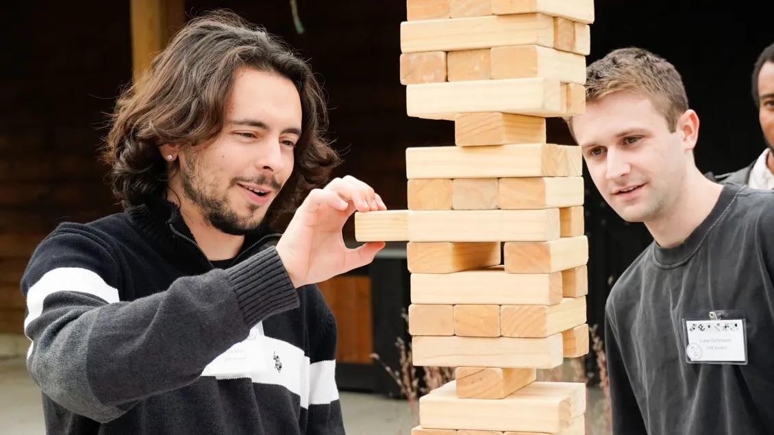 Two students play Jenga at CMB student event