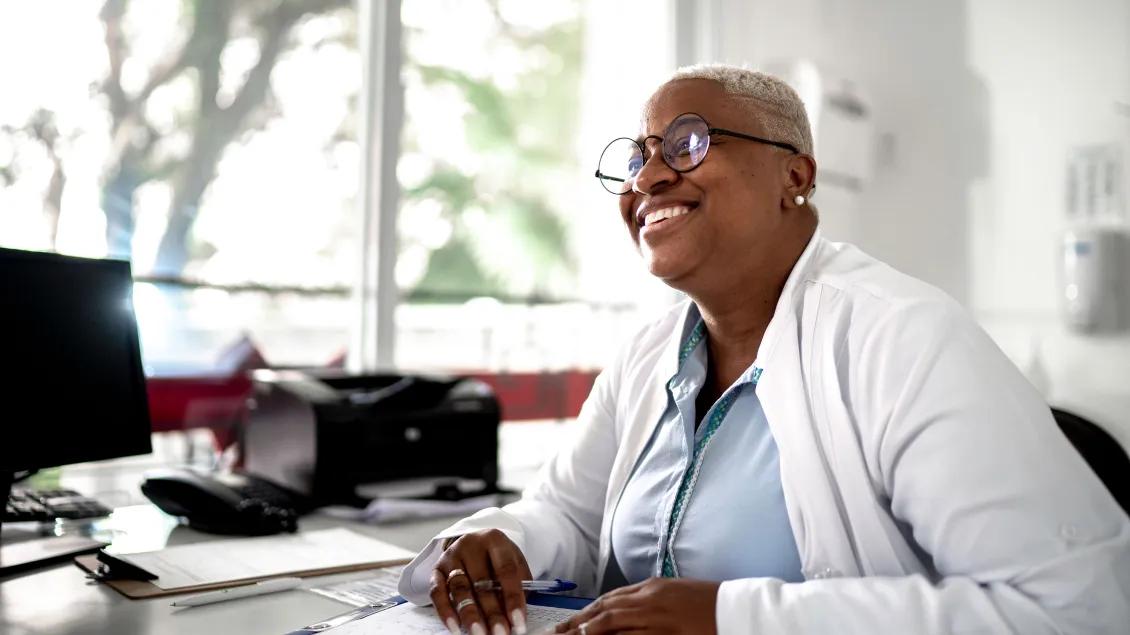 Doctor smiling and sitting at desk