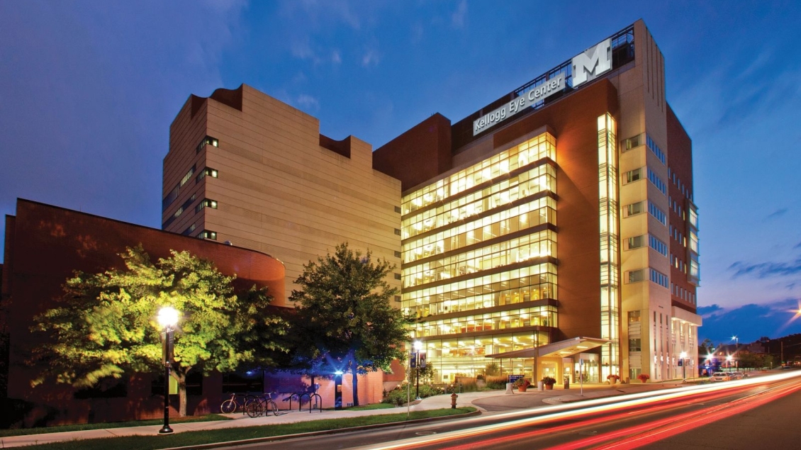 Kellogg Eye Center at night with lights on in the building