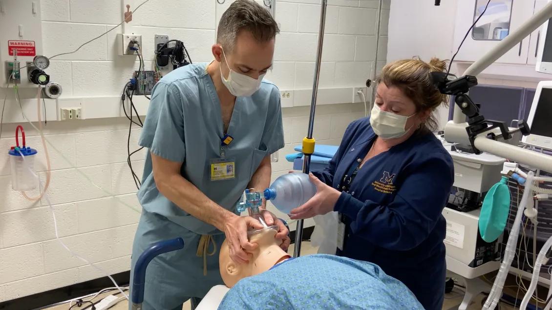 Team members demonstrating a medical technique with a dummy