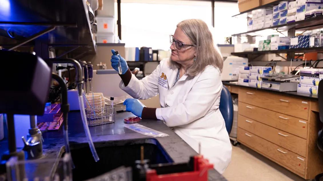 Dr. Dawid in the Pediatric Infectious Disease lab looking at lab samples.