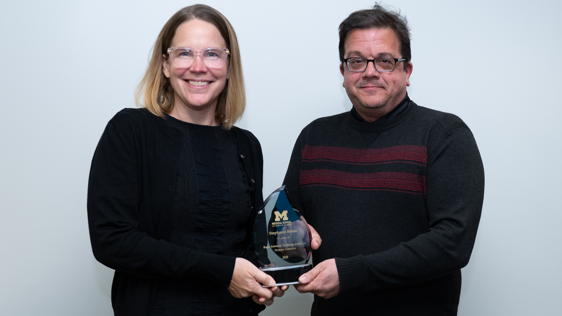 twp faculty professors standing together holding a glass award