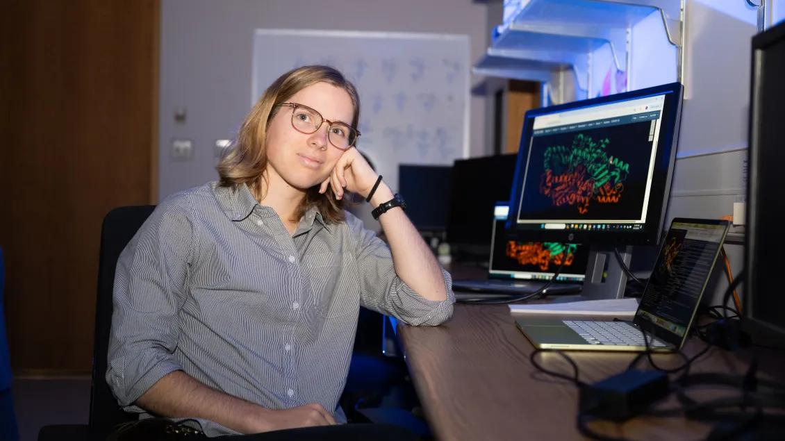 scientist by computer screen displaying a protein structure