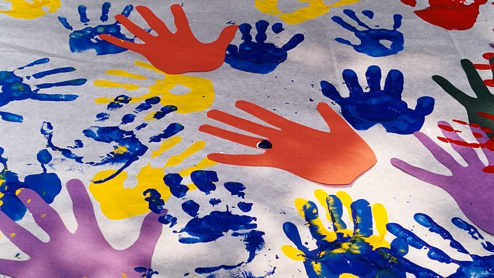 Colorful handprints in paint on a white sheet