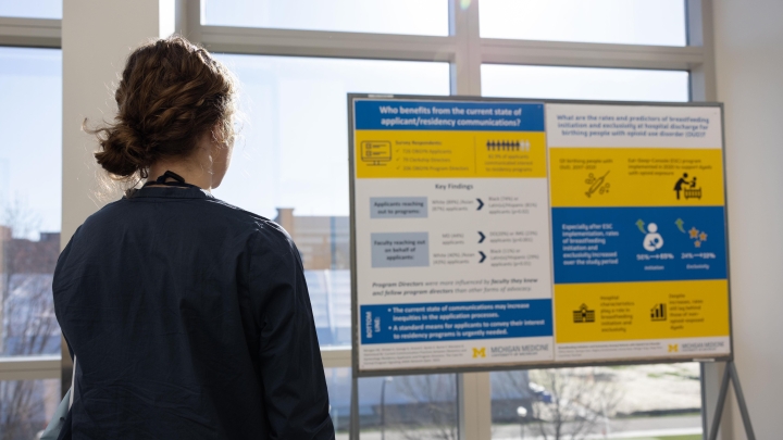 woman views obgyn content poster on research day