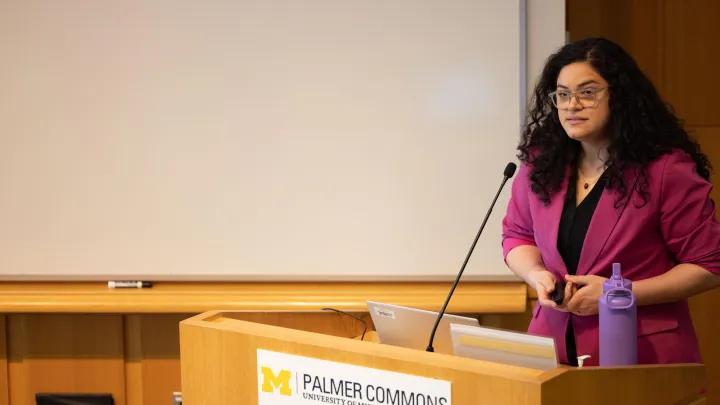  woman gives speech at podium for obgyn research day 
