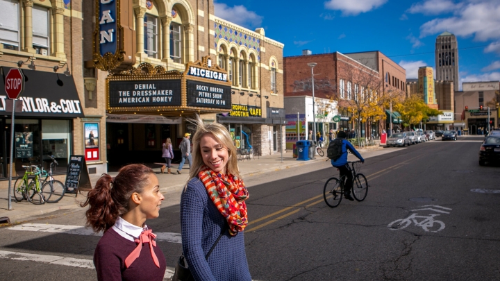 Two people crossing the street in downtown Ann Arbor