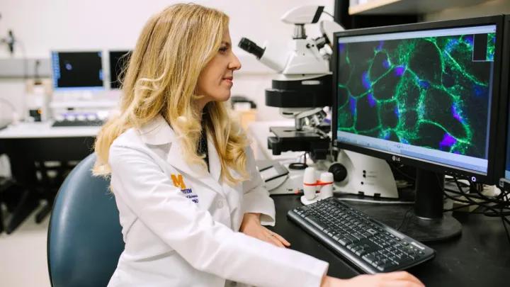 Researcher looking at equipment at Kellogg Eye Center