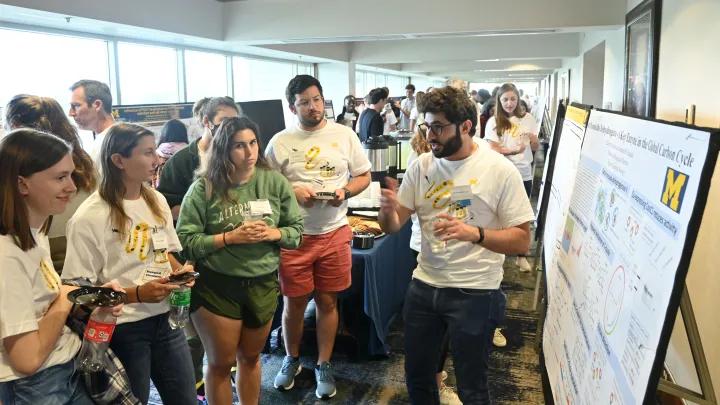 Biochemistry students look at a research poster at an event