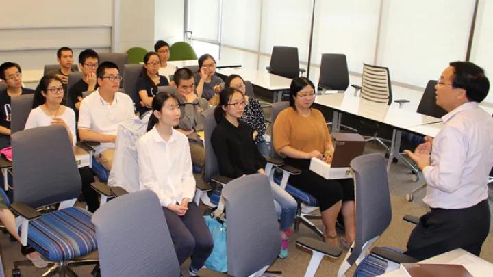 a group of people in a classroom listening to a lecture