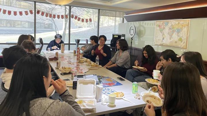 Students sitting at a table eating.