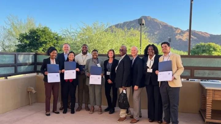 Participants & mentors stand outside with certificates, smiling, with a mountain backdrop—group photo from a PROSPECT event