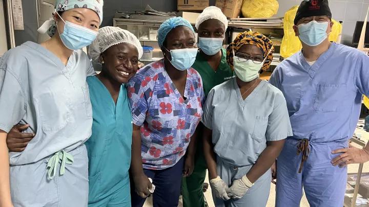Six medical professionals wearing scrubs and surgical masks