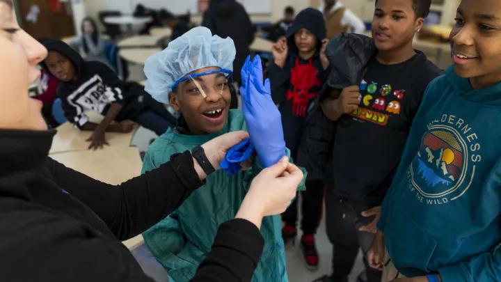 Middle school student putting on PPE