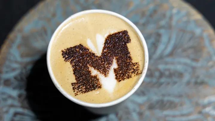 A Block M design on top of a cup of coffee