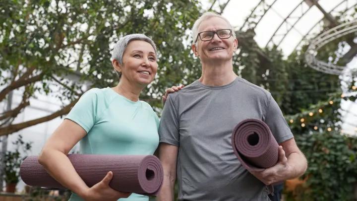 elderly coupling holding yoga mats