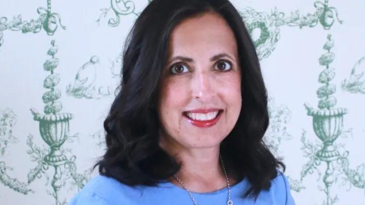 Portrait of a smiling woman in a blue top.